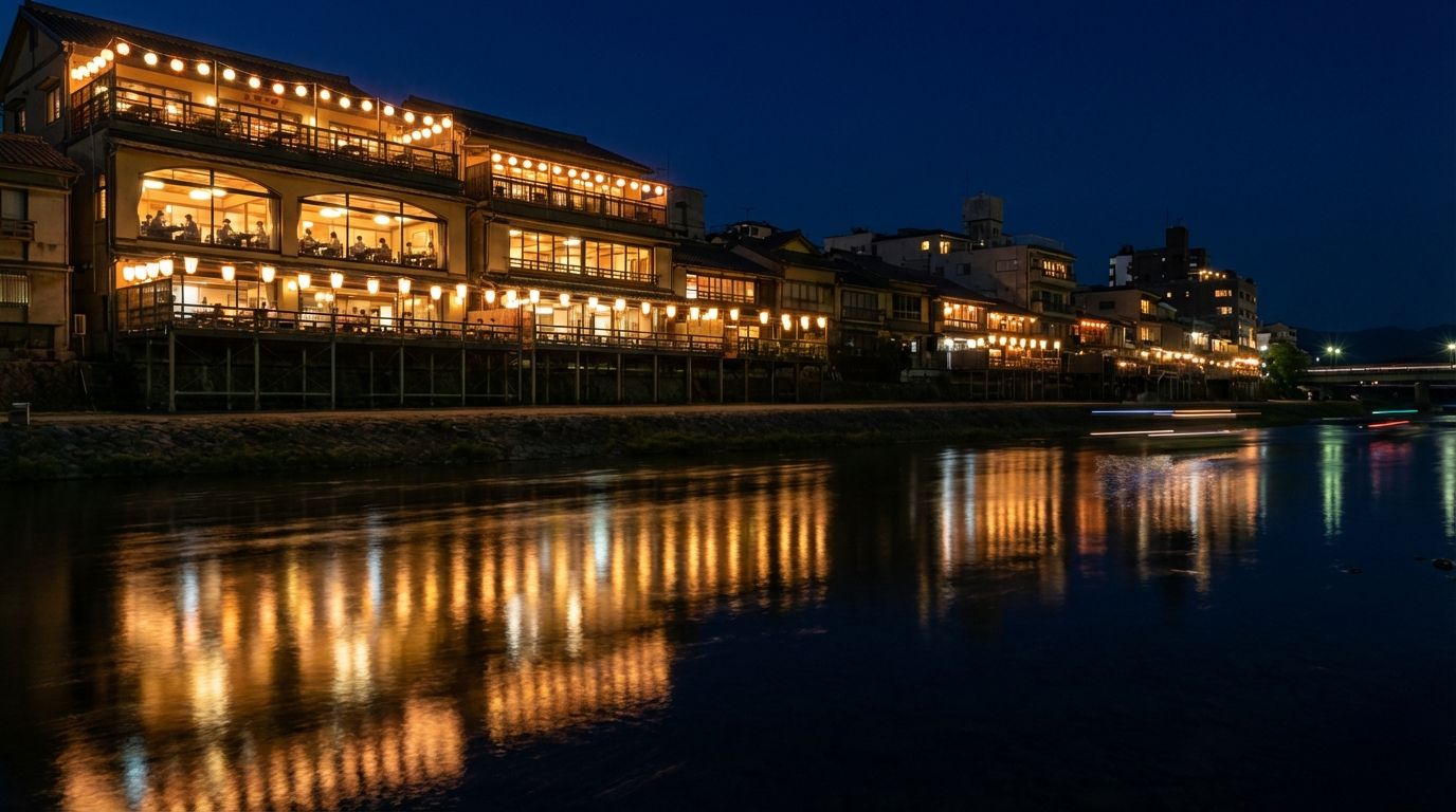 조명 밝은 건물이 물에 반사되는 밤의 리버사이드 레스토랑, 창문 너머로 식사하는 손님이 보이는